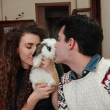Two people interacting with a rabbit indoors.