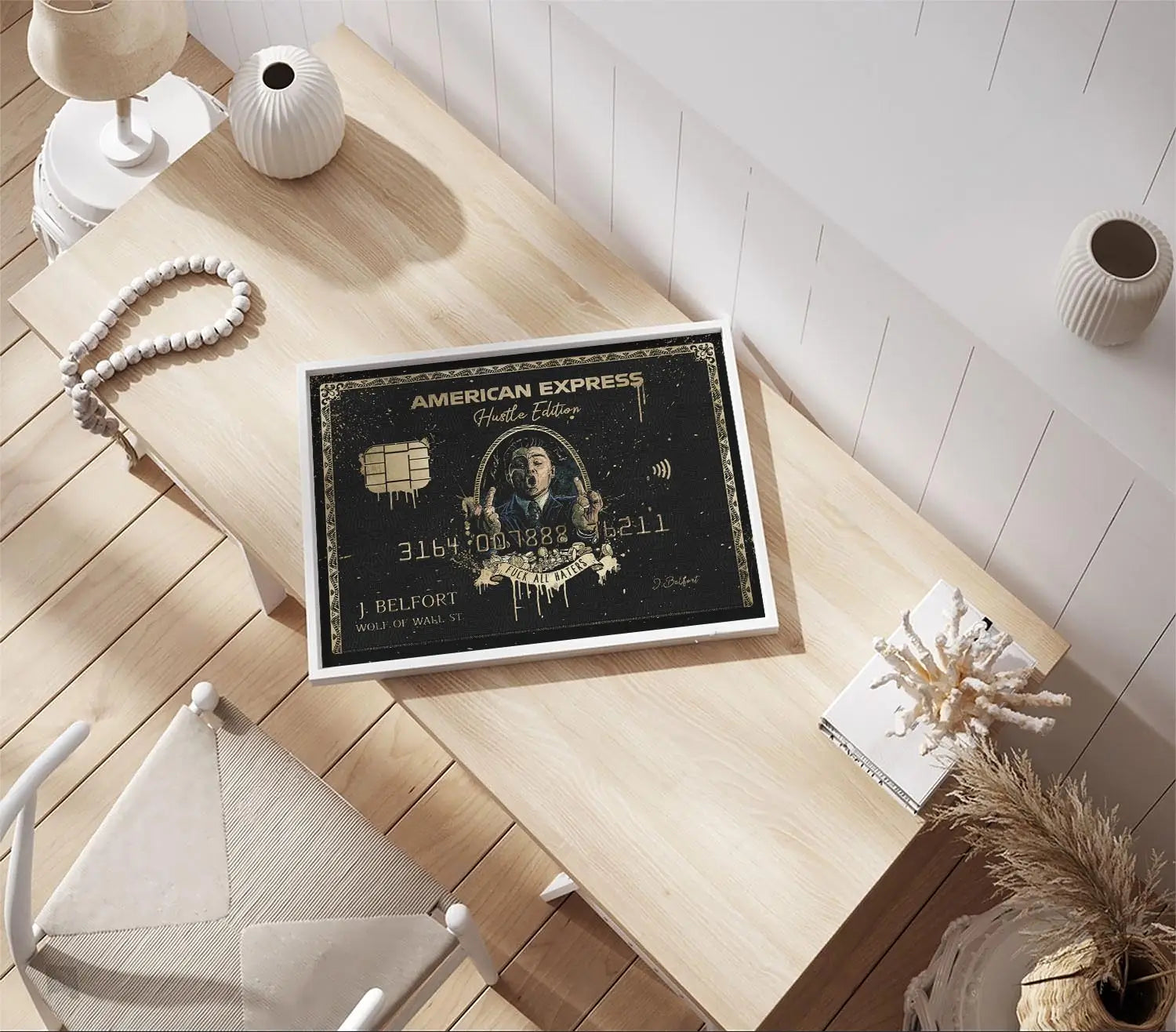 Wolf of Wall Street Amex canvas art on a wooden desk in a bright, modern office setup viewed from above
